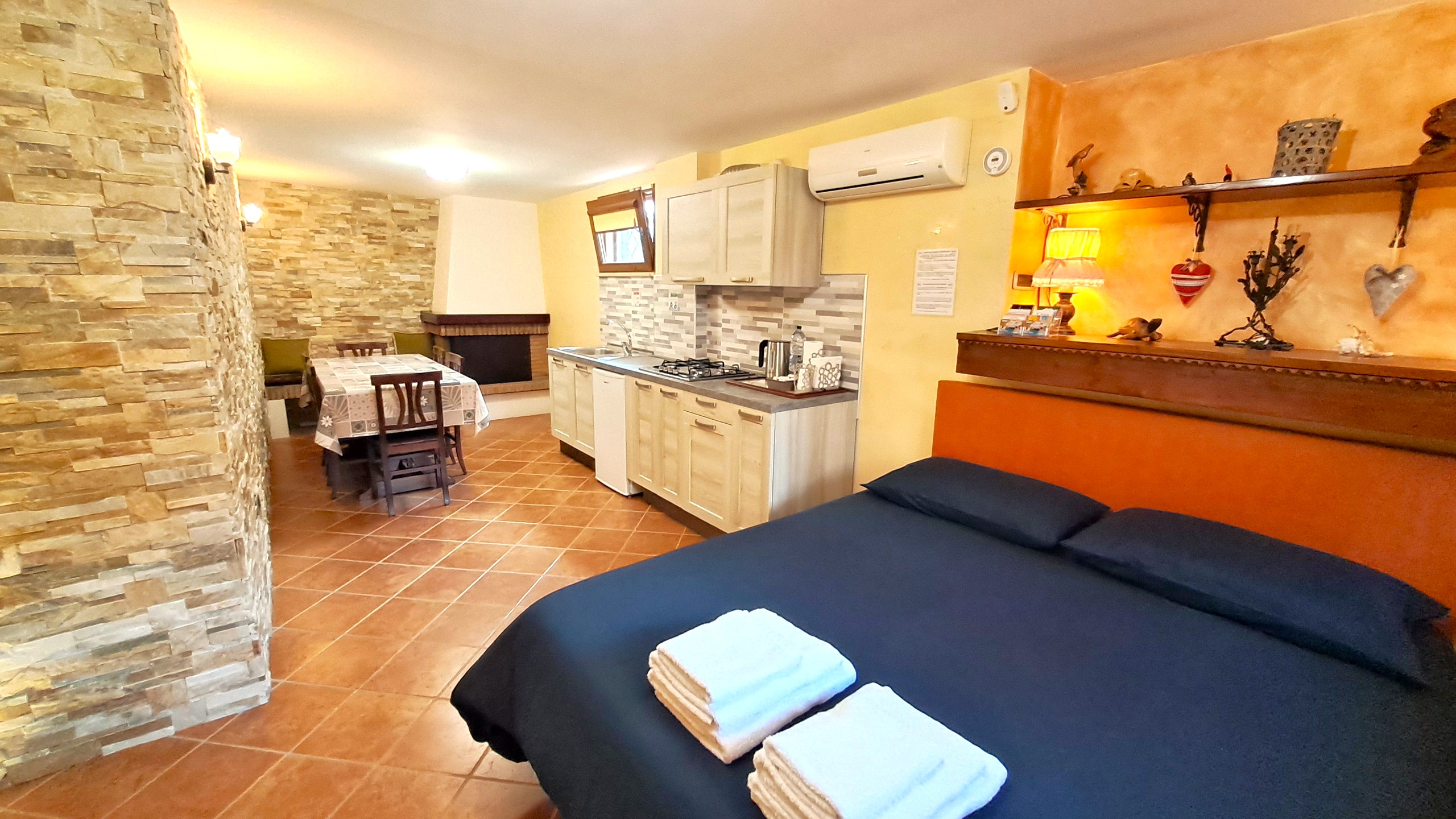 Alloggio Gladiolo - Letto Cucina Tavolo e Camino 01